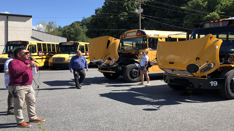 Electric school buses in parking lot.